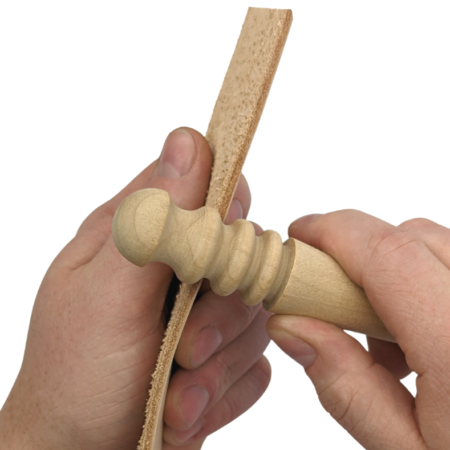 The Artisan Essentials Multi-Size Wooden Slicker being used to burnish the edge of a piece of leather