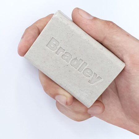 Close up of a hand holding a Bradley heavy-duty soap bar